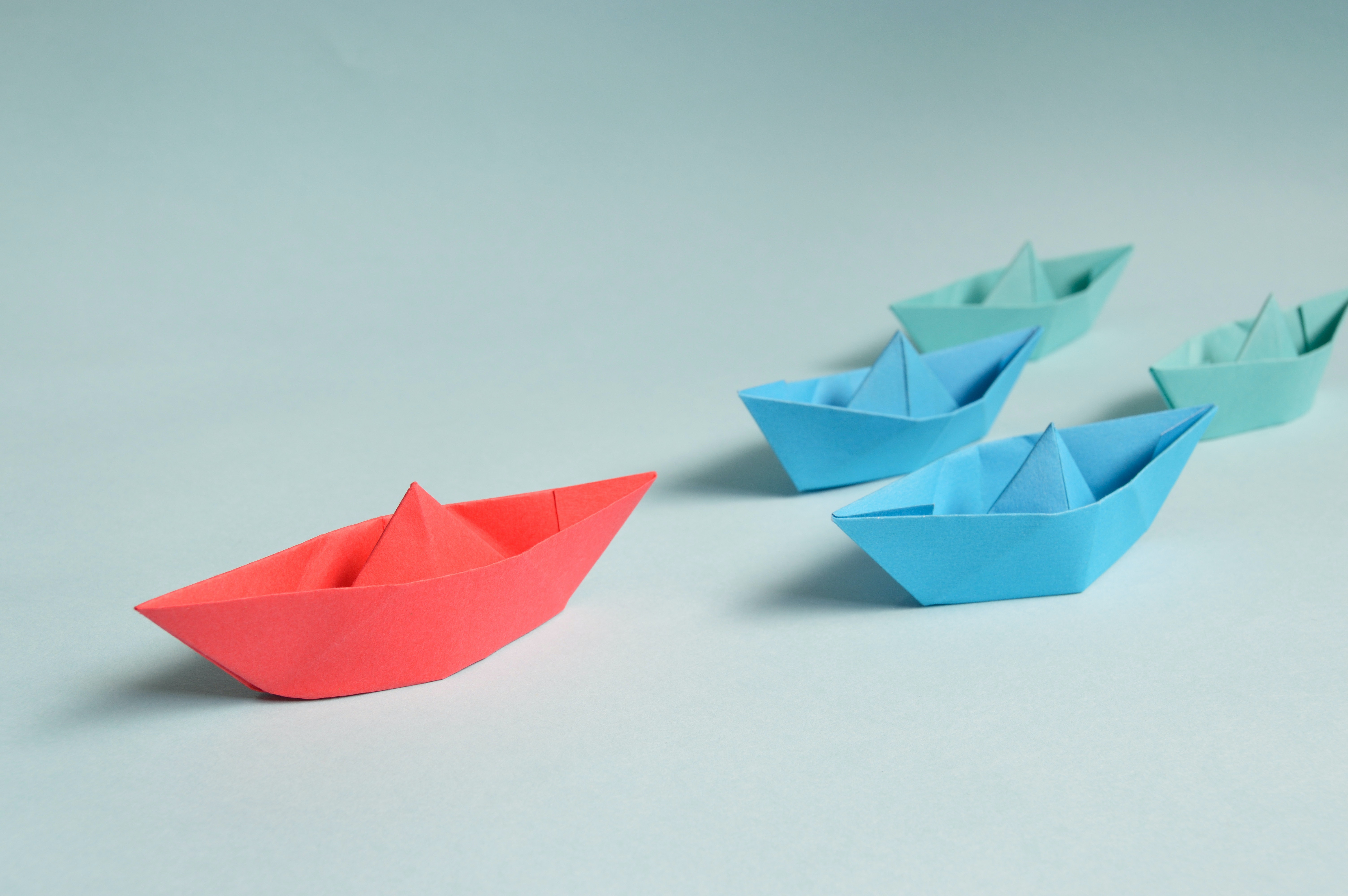 A paper boat leading other boats as an illustration of effective leadership